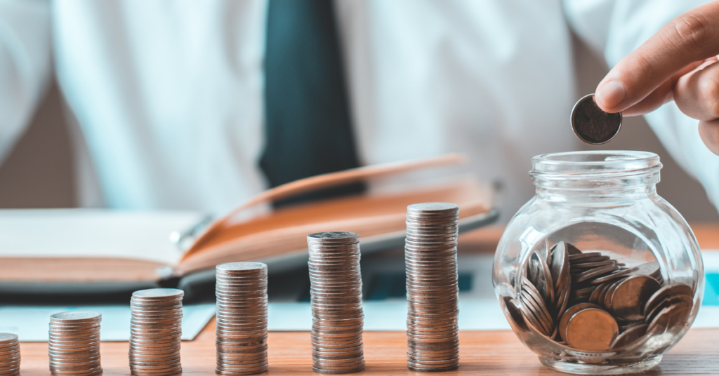 A picture of a man taking pennies from a jar and stacking the up in piles 